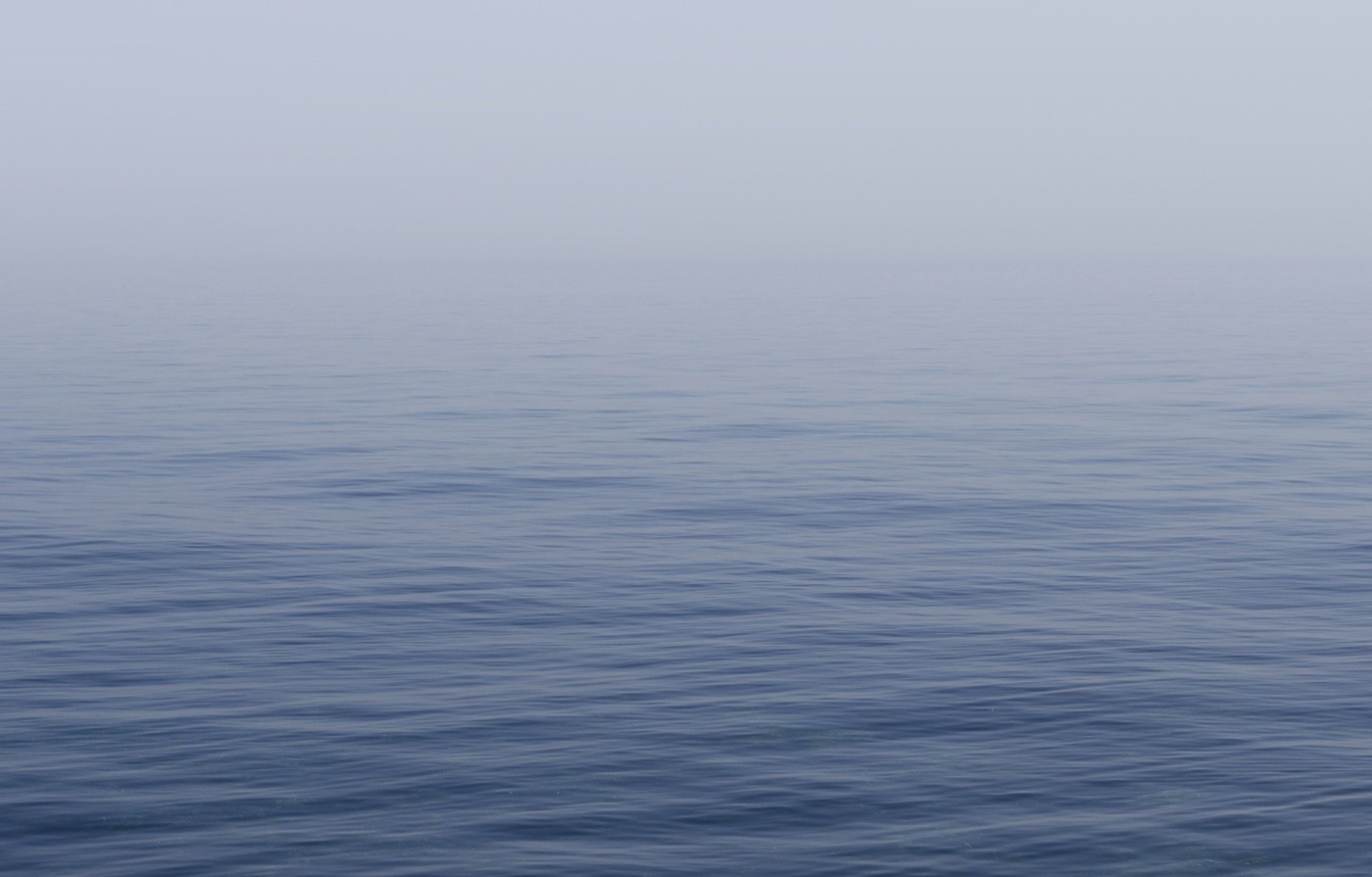 Superfície del mar en calma sota una llum suau